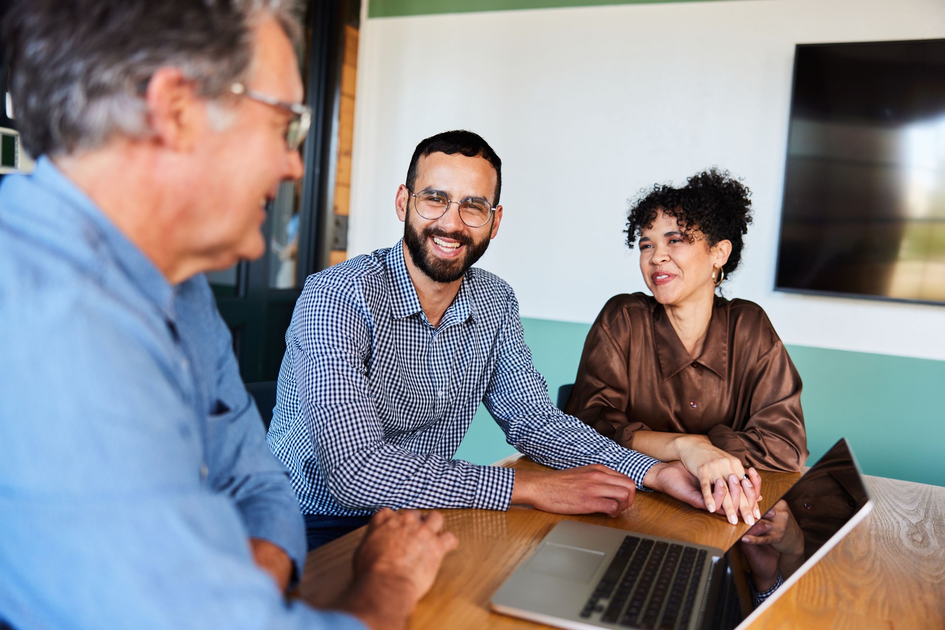 Smiling young couple talking with their financial advisor in his office